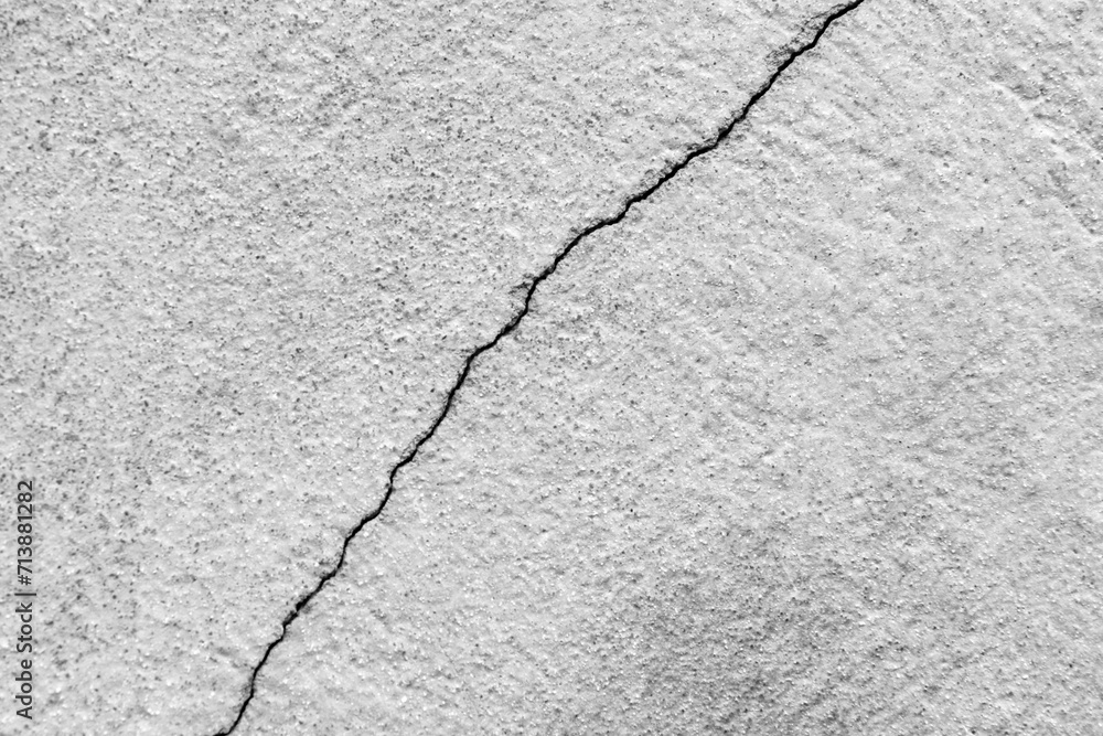 Obraz premium Big crack on old plastering wall. Long winding ascending crack in cement surface of an old building. Copy space. Selective focus.