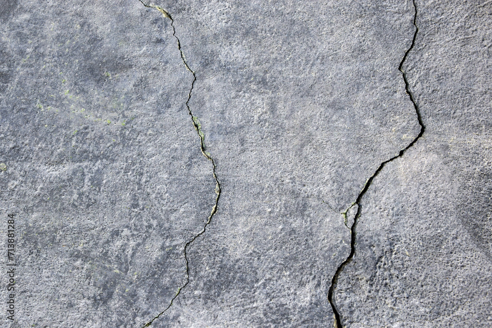 Obraz premium The wall of an old building with many winding, deep cracks. Copy space. Selective focus.