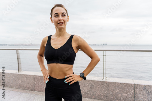 Athletic woman pausing workout to check fitness tracker.
