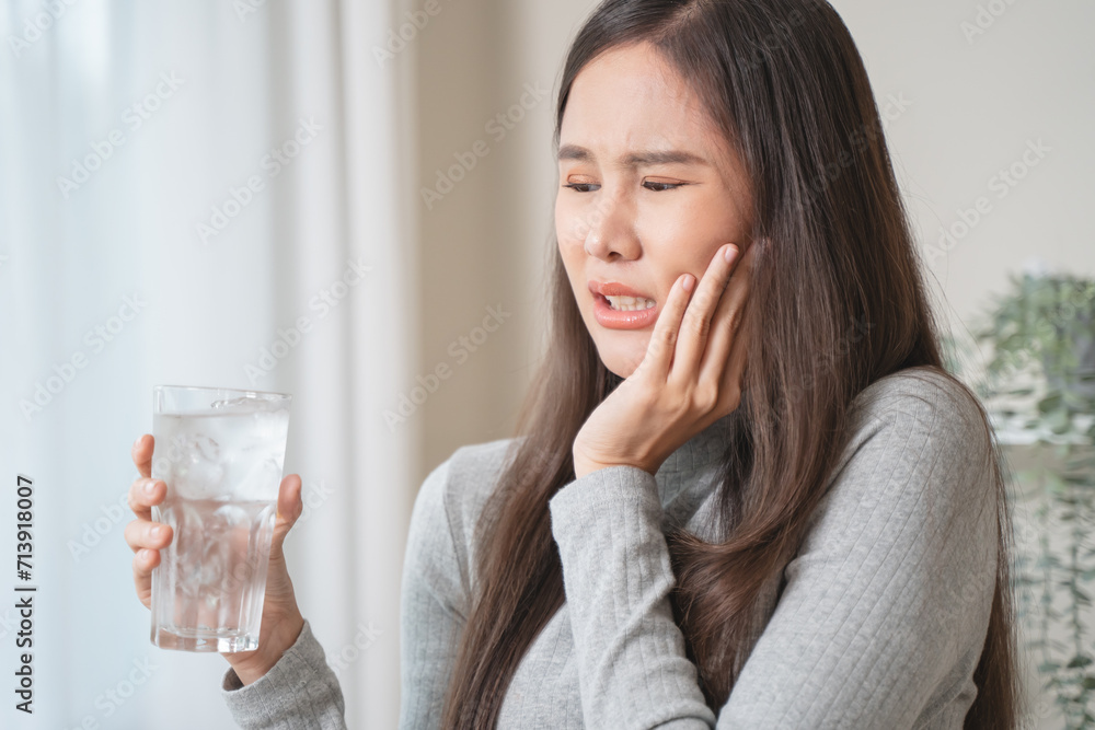 Face expression suffering from sensitive teeth, Asian young woman touching cheek Face expression suffering from sensitive teeth, Asian young woman touching cheek