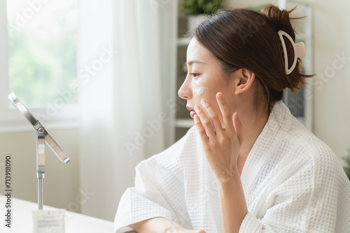 Effortless Elegance: A Serene Moment of Self-Care as a Woman Applies Luxurious Moisturizing Cream for Glowing, Nourished Skin and Unveils the Beauty of Skincare Rituals