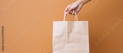 Capture the simplicity and purity of a white paper bag in hand, colored background photo