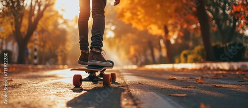 Carefree skater girl on her skateboard riding longboard on an empty road holding hands sideways and laughing. Creative Banner. Copyspace image