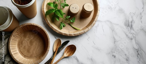 eco friendly disposable dishes made paper and bamboo on white marble background Draped spoons fork knives plate with paper cups recycling concept Zero waste copy space. Creative Banner photo