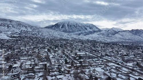 Aerial Lindon Utah residential neighborhood winter. Winter season with snow in Wasatch Mountain range valley. Residential homes along mountain and valley. Residential streets and roads.