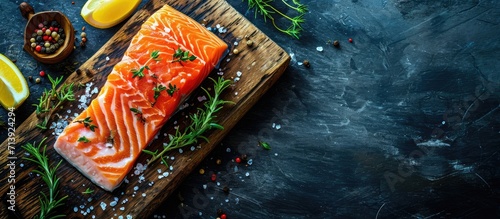 Fresh raw scandinavian salmon fillet Rosemary and thyme Salt and pepper On old wooden board Pescetarian seafood for cooking Preparation nutrition seafish Horizontal top view. Creative Banner photo