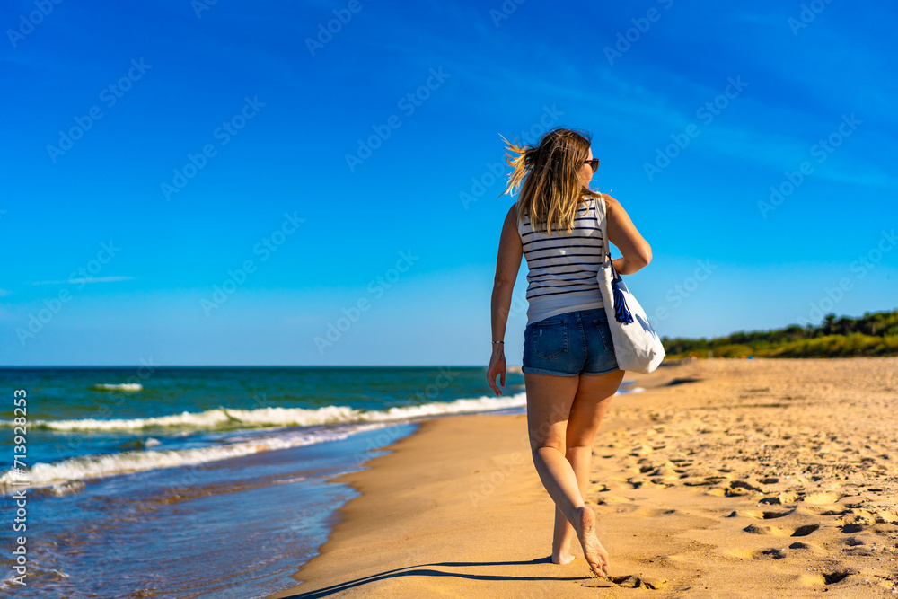 Beautiful mid adult woman walking on sunny beach
Beautiful mid adult woman walking on sunny beach