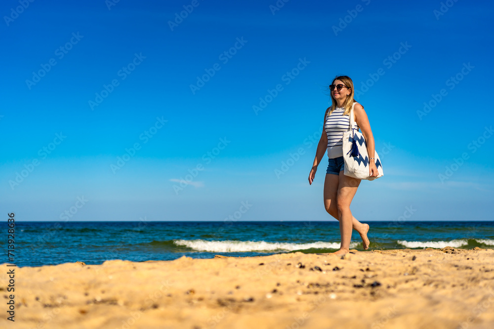 Beautiful mid adult woman walking on sunny beach
Beautiful mid adult woman walking on sunny beach