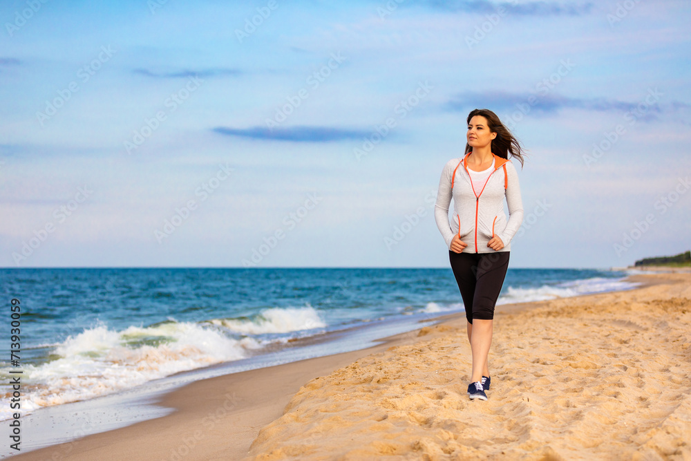 Beautiful mid adult woman walking on beach 

