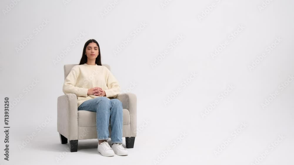 Portrait of a serious Caucasian woman sitting in a armchair on white background Portrait of a serious Caucasian woman sitting in a armchair on white background