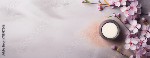 spa products on white table with fresh flower buds isolated on pink background, in the style of dark beige and gray, cherry blossoms, use of paper, dark violet and beige photo