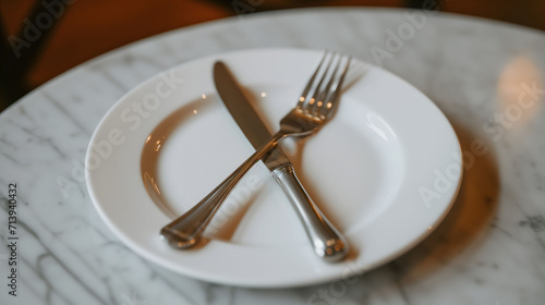 Stainless Steel Knife and Fork Crossed on White Plate