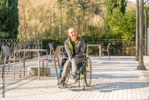 Disabled man in wheelchair enjoying the sun in the park