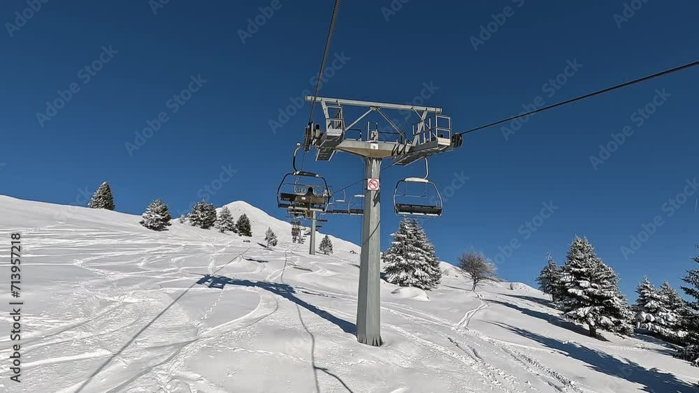 Passo del Tonale, Ponte di Legno, Italy. Chairlift with skiers is moving to the top of the ski runs in a wonderful sunny day. Best ski resort Passo del Tonale, Ponte di Legno, Italy. Chairlift with skiers is moving to the top of the ski runs in a wonderful sunny day. Best ski resort