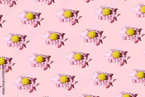 Wilted garden flowers, creative floral pattern, concept of decay of beauty, depression, sadness, pastel pink background.