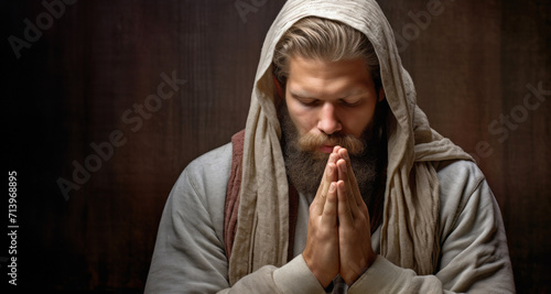 Closeup portrait of a bearded man praying with his hands clasped