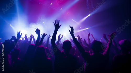 Energetic Crowd at a live concert with hands raised and colorful vibrant stage lights  music festival excitement concept