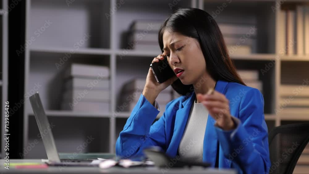 I dont want to hear excuses, just get it done. Serious Asian Businesswoman talking on mobile phone during a late night in the office.