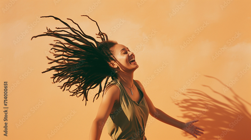 Happy young carefree candid black woman flipping her dreadlocks hair in