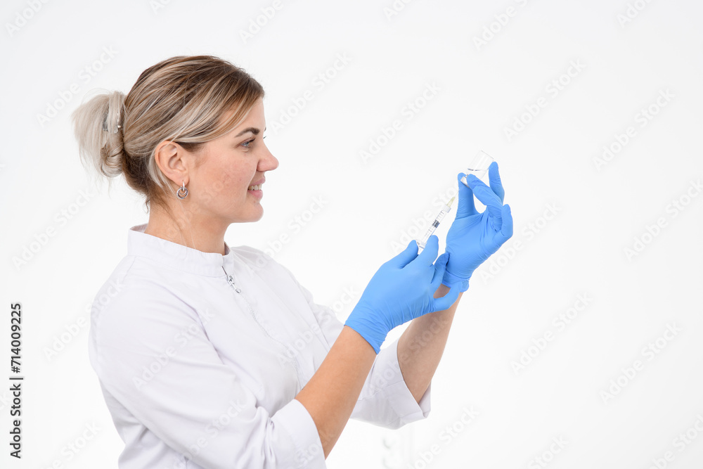 Side view of a smiling beautician filling a syringe with a drug for botox injection from an ampoule Side view of a smiling beautician filling a syringe with a drug for botox injection from an ampoule