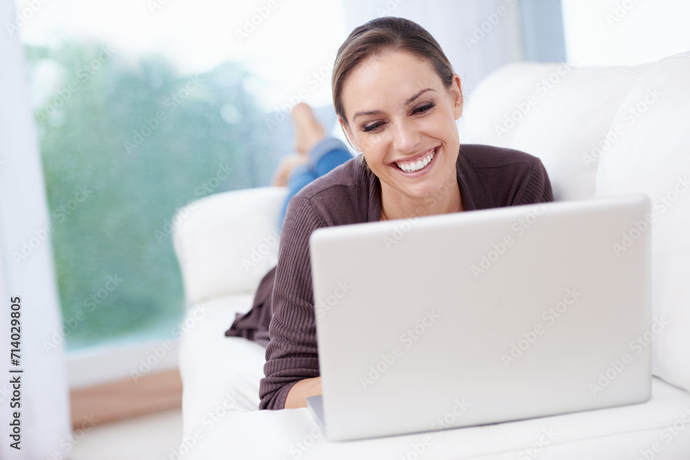 Naklejka premium Happy woman, laptop and relax on couch for remote work, streaming movies and update blog post at home. Freelancer, computer and download subscription, online shopping and search news on social media