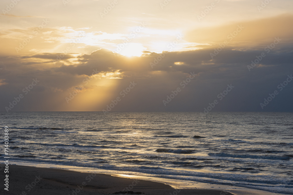 Scenic seascape with rays of light shining through the sky.