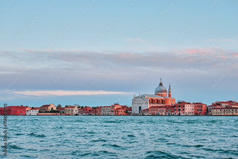 A beautiful shot of the Il Redentore and Santissimo Cathedral across the water at sunset, Venice, Italy
