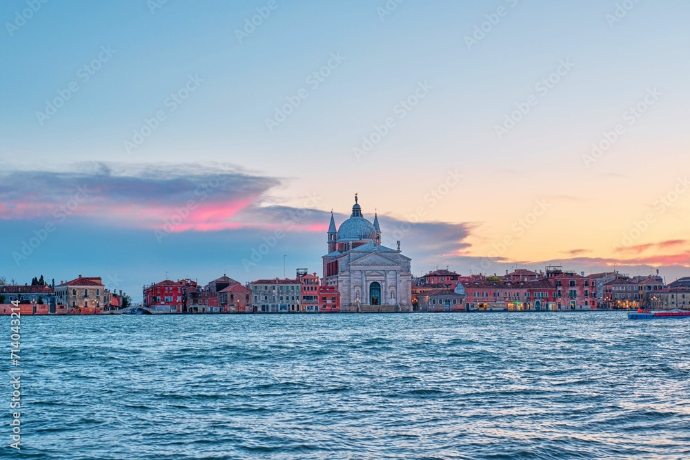 A beautiful shot of the Il Redentore and Santissimo Cathedral across the water at sunset, Venice, Italy