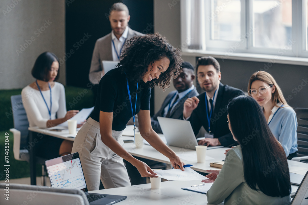 © gstockstudio - Happy African female business mentor talking to audience during a conference in convention center