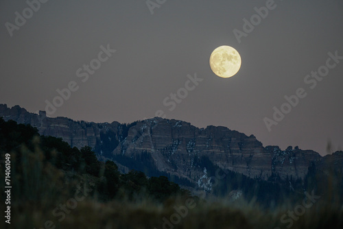 Golden moonrise over mountains at dusk