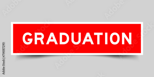 Red color square shape sticker label with word graduation on gray background