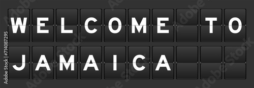 Black color analog flip board with word welcome to jamaica on gray background