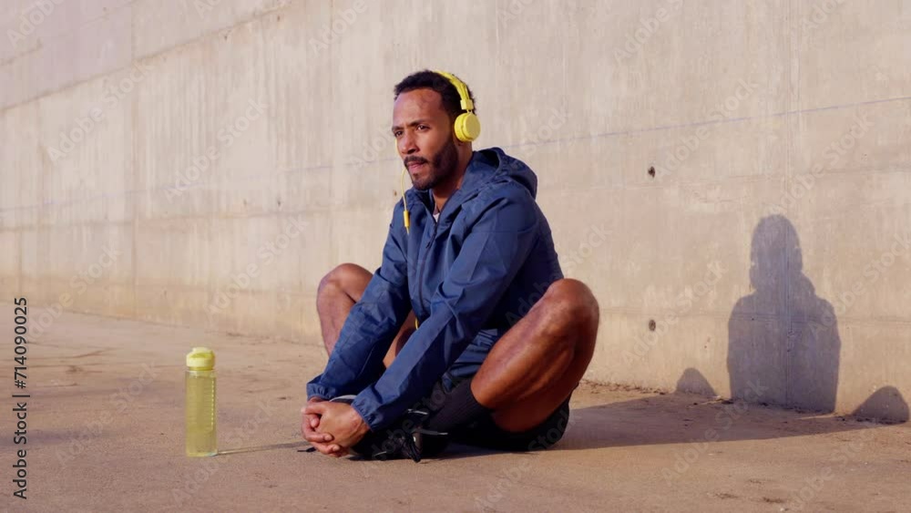 Sporty young man with sports headphones doing stretches outdoors. Sporty young man with sports headphones doing stretches outdoors.