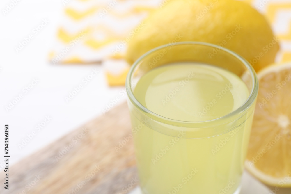 Shot glass with tasty limoncello liqueur on table, closeup. Space for text Shot glass with tasty limoncello liqueur on table, closeup. Space for text