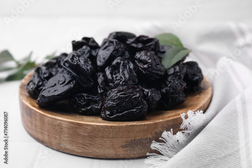Sweet dried prunes on white table, closeup