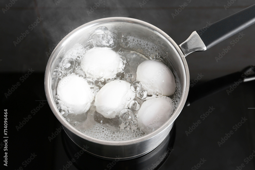 Chicken eggs boiling in saucepan on electric stove, above view Chicken eggs boiling in saucepan on electric stove, above view