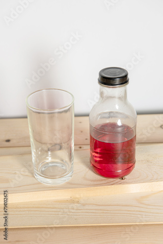 Glass bottle filled with refreshing liquid sits on the table in a bar, surrounded by glass