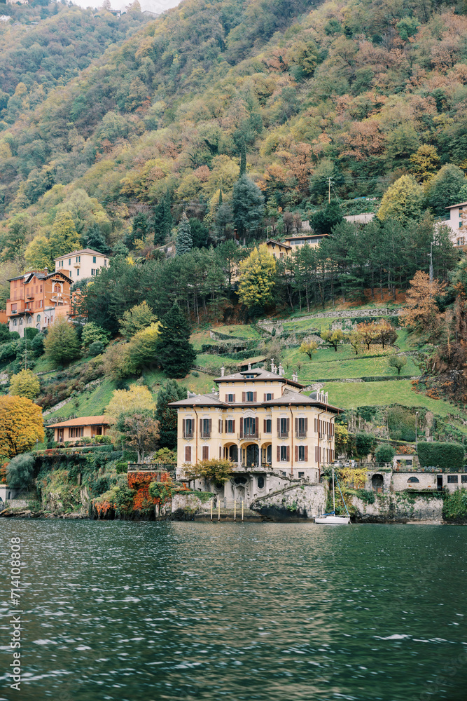 Villa Cornaggia on the shores of Lake Como at the foot of forested mountains. Italy