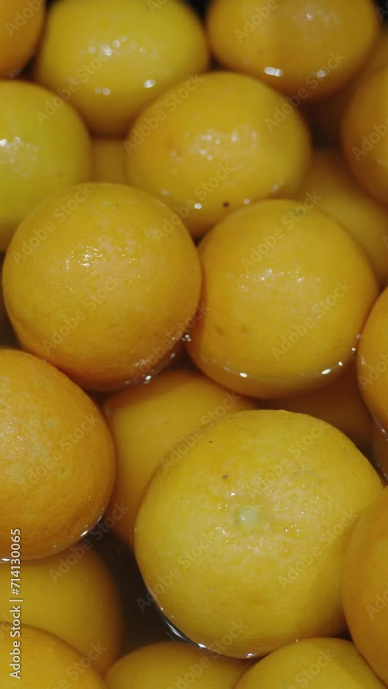 Vertical video. Oranges in water, close-up in slow motion. Vertical video. Oranges in water, close-up in slow motion.