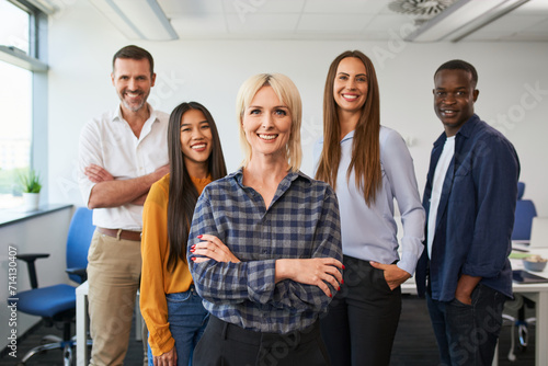 Group portrait of female entrepreneur with group of colleagues standing together at office photo
