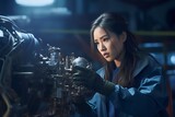Asian Female helicopter mechanic checking parts with flashlight