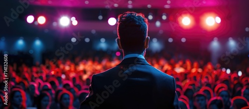 Motivational speaker discussing happiness, self, success, empowerment, efficiency, health, and productivity on stage in a large conference hall with cinematic lighting. photo