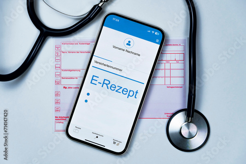 Smartphone mit e Rezept auf dem Display liegt auf herkömmlichen Kassenrezept, ein Stethoskop liegt daneben, horizontal, weißer Hintergrund 