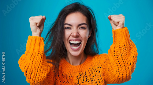 A young excited woman shouts and makes a victorious gesture