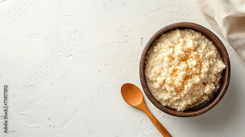 A white background features a bowl of oatmeal porridge with syrup on top, big space, Generative AI. photo