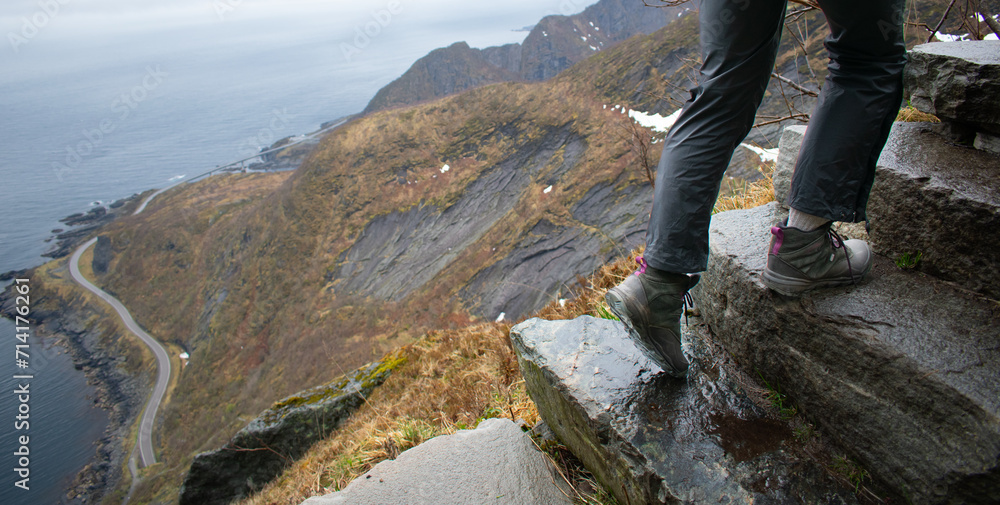 Female hiker climbing Old stone staircase once used by ancient monks. Reine, Lofoten, Norway Female hiker climbing Old stone staircase once used by ancient monks. Reine, Lofoten, Norway