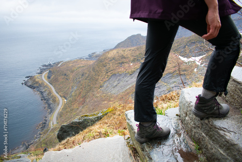 Female hiker in Lofoten Norway climbing old stone staircase once used by ancient monks. Reine, Norway