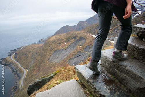 Female hiker climbing Old stone staircase once used by ancient monks. Reine, Lofoten, Norway