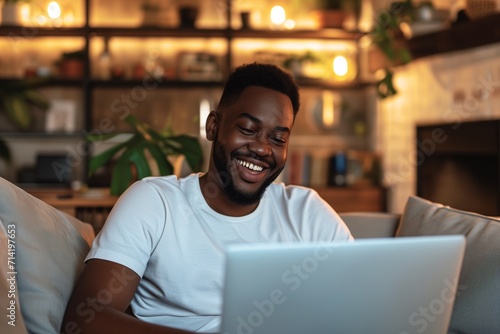 Smiling Man Using Laptop in Cozy Living Room © Nuttakarn