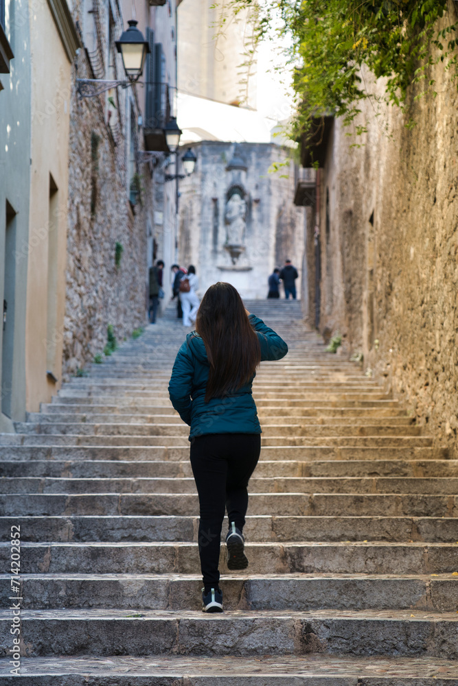 Lonely asian girl walking in Girona streets. 
